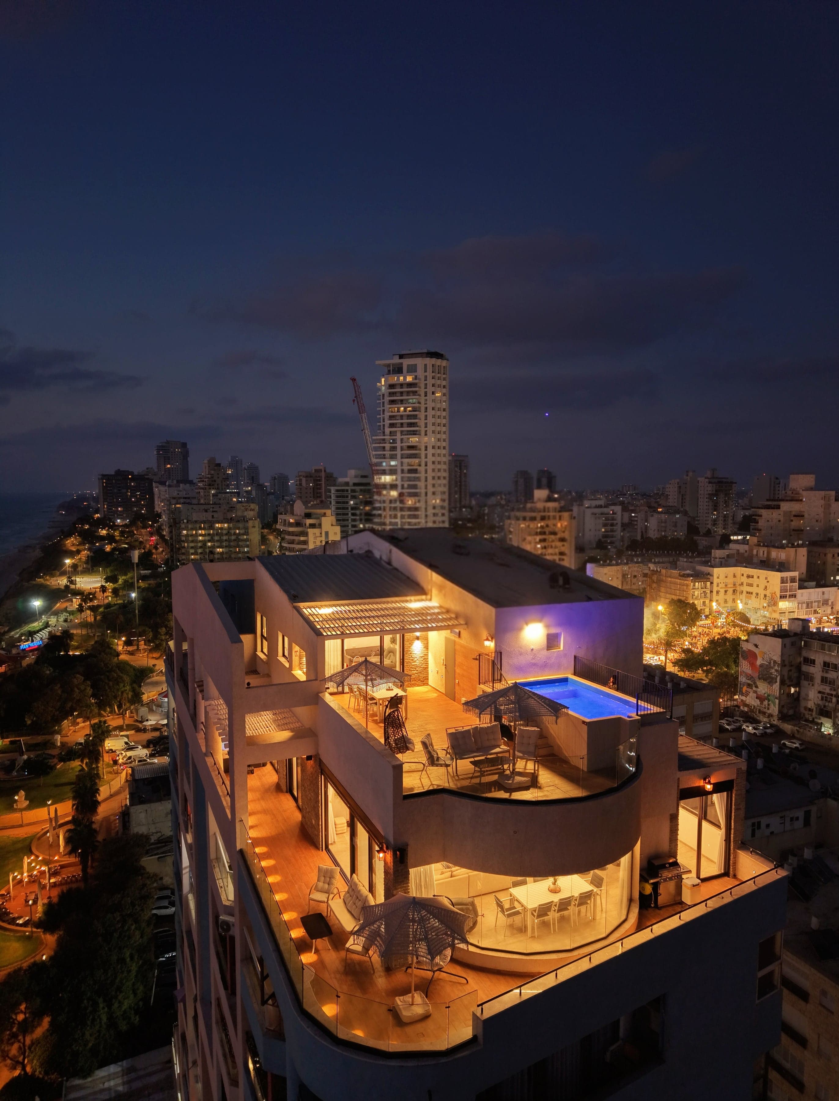 שני מפלסי הפנטהאוזים בשעת ערב, מול קו החוף והעיר